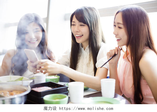 年轻妇女组吃火锅和拍照通过电话